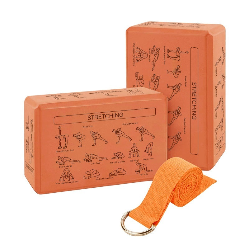 Two orange yoga blocks with stretching illustrations and an orange yoga strap on a white background
