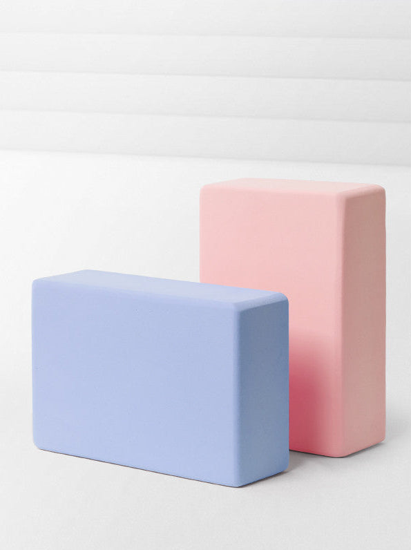 Two rectangular foam blocks, one pink and one blue, on a light gray background.