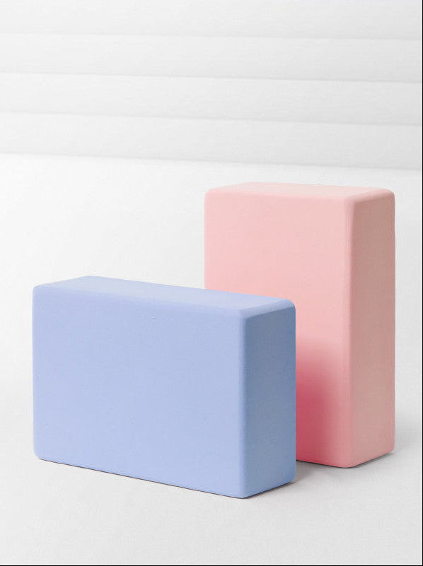 Two rectangular foam blocks, one pink and one blue, on a light gray background.