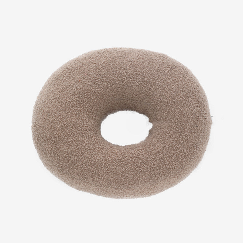 Round beige donut cushion on a white background