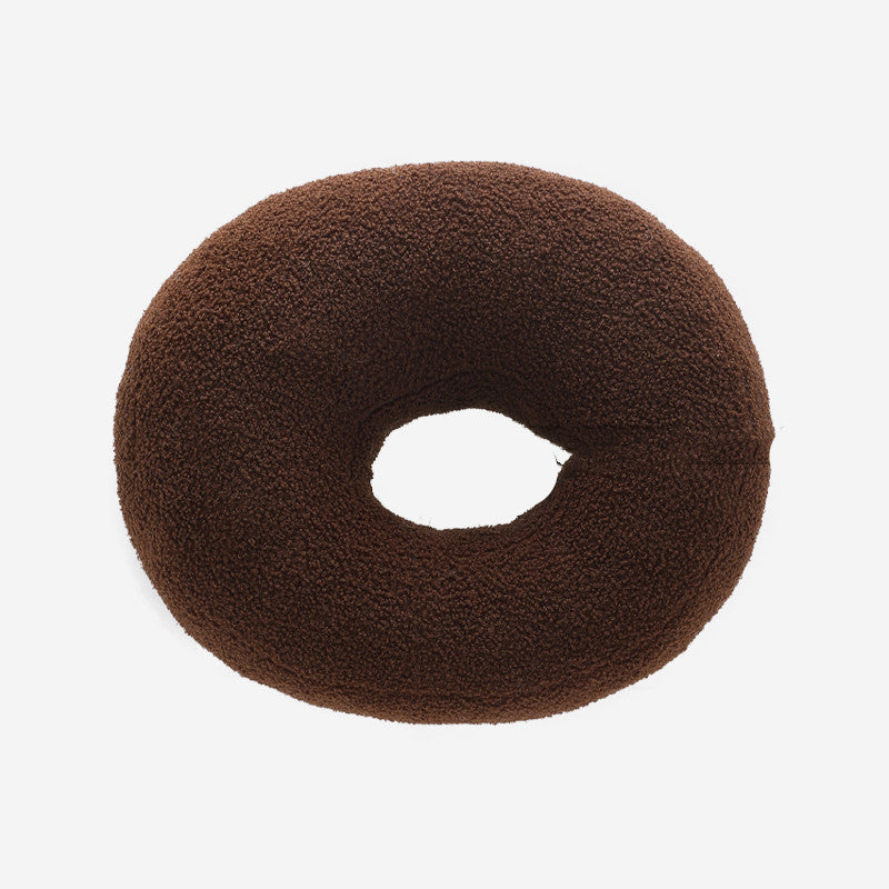 Brown donut-shaped pillow on a white background