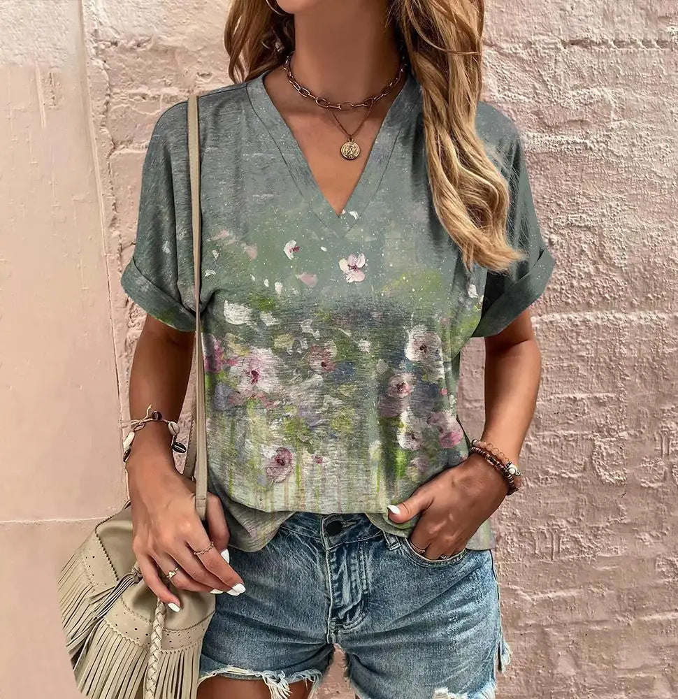 Woman wearing a floral blouse and denim shorts against a textured wall.