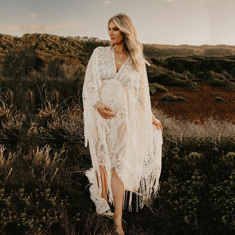Woman in a white lace dress standing in a natural landscape
