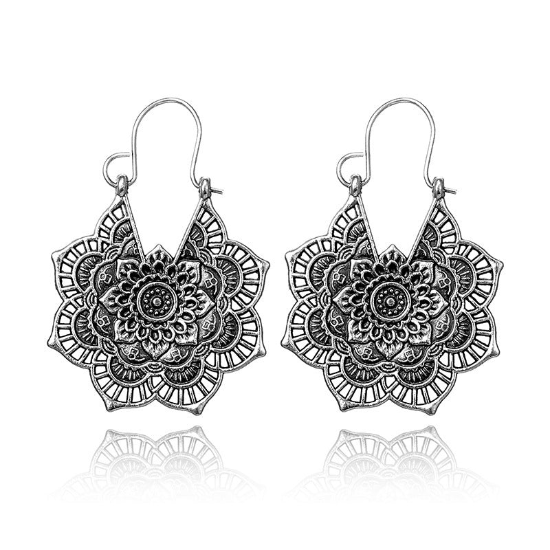 Pair of silver mandala earrings on a white background