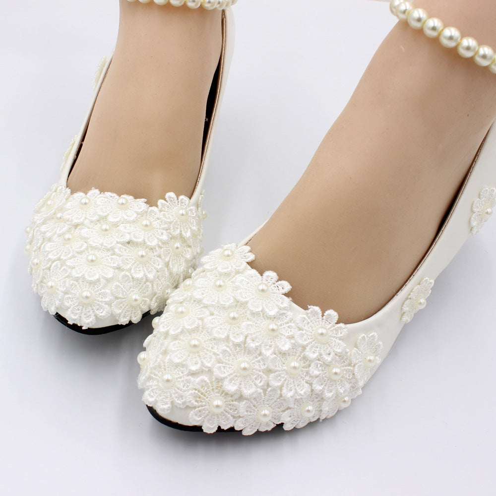 White pearl embellished wedding shoes on a white background