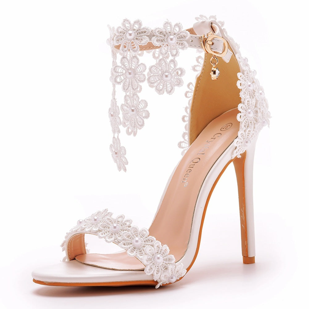 White high-heeled shoe with lace detailing on a white background