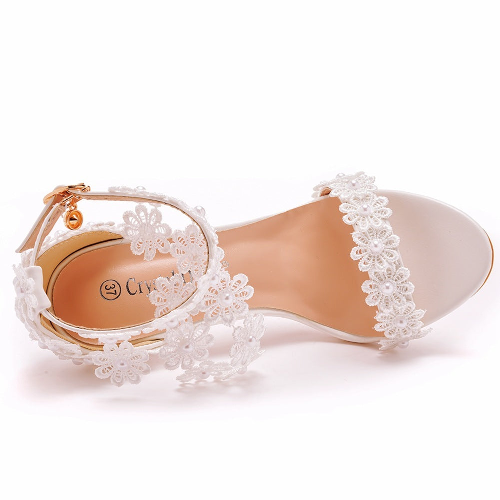Delicate sandal with floral lace details on a white background