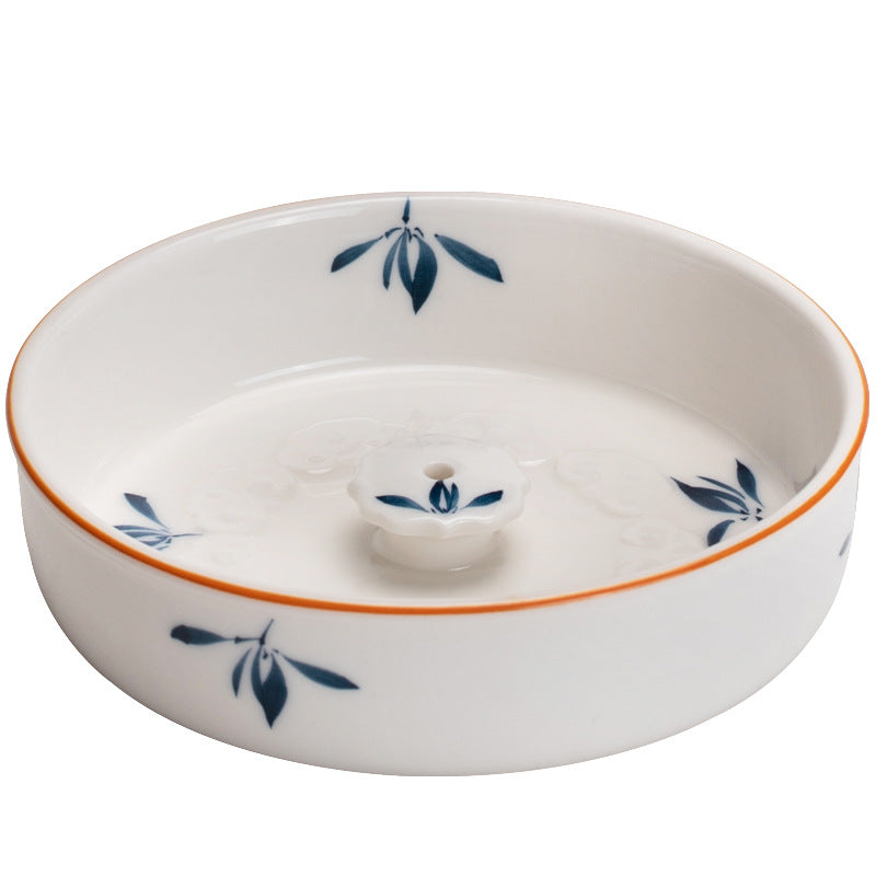 White ceramic dish incense holder with blue leaf patterns on a white background