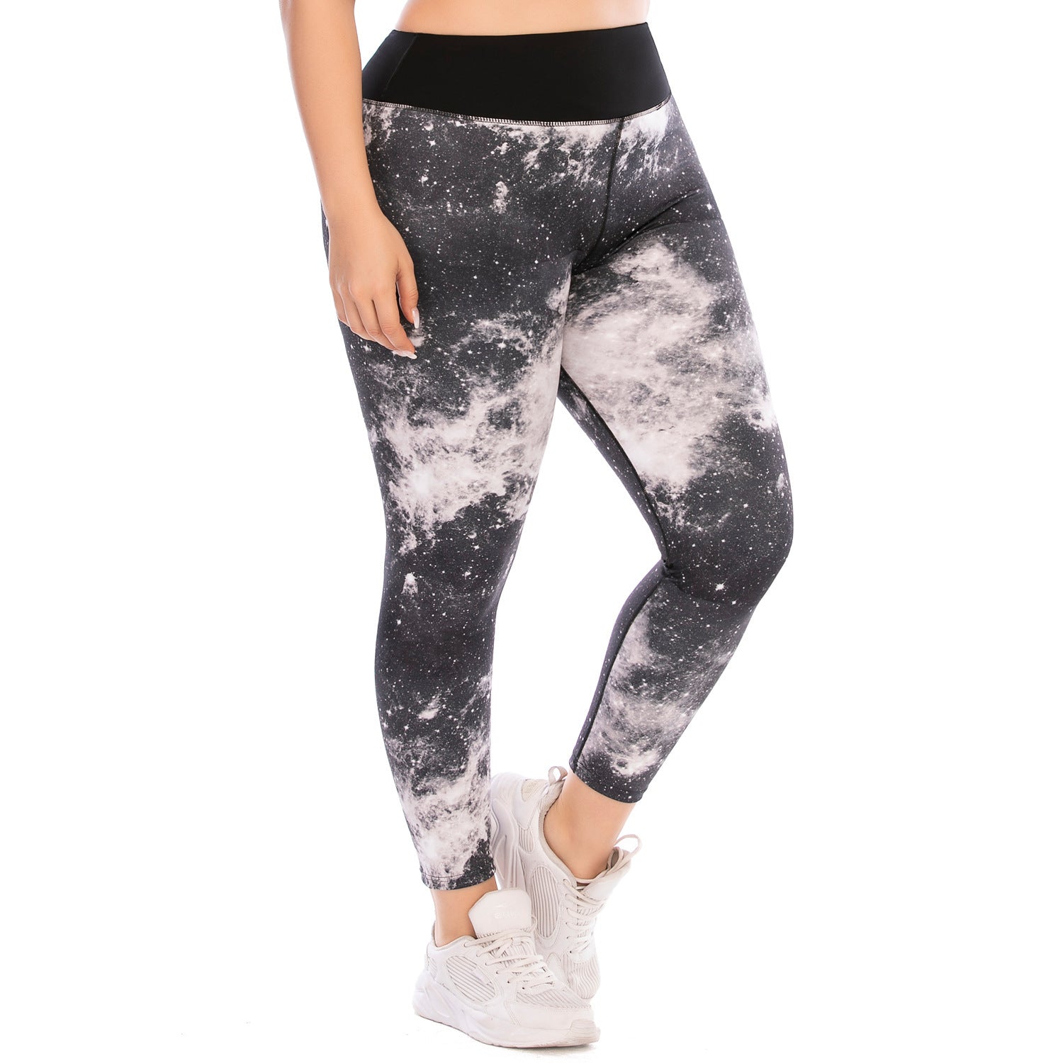 Person wearing black and white patterned leggings on a white background