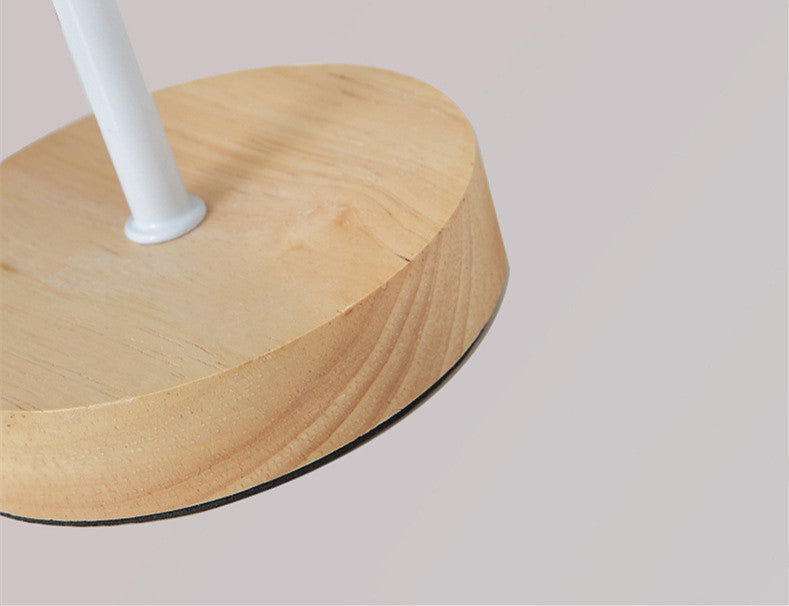 Wooden base with a white cylindrical object on a light gray background