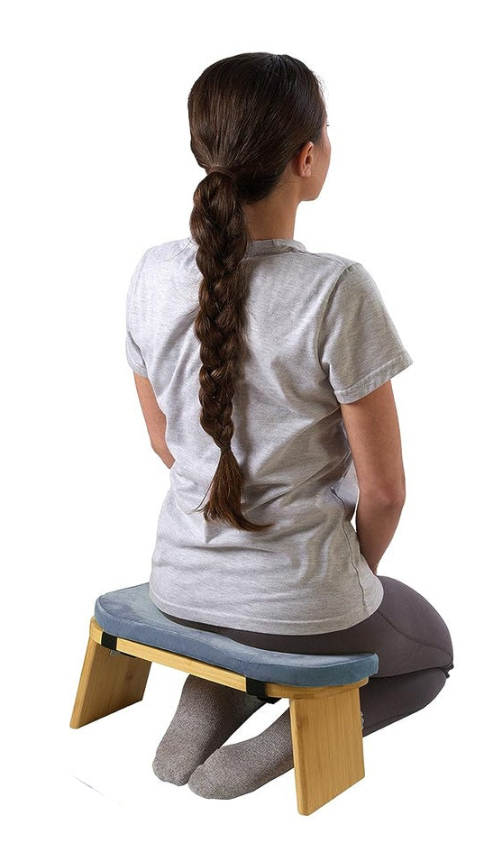 Wooden bench with blue cushion and carrying case on a white background