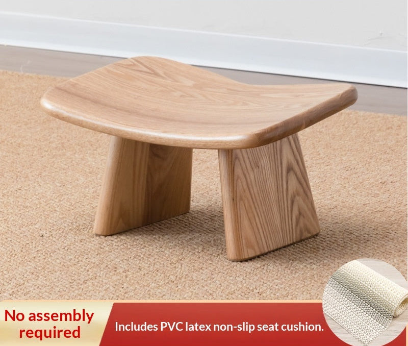 Wooden stool on a carpeted floor with text about recommended height and non-slip seat cushion.