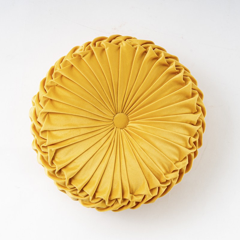 Yellow pleated round pillow on a white background