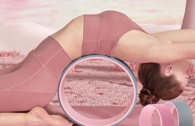 Woman using a pink and gray exercise wheel with text on a blurred outdoor background