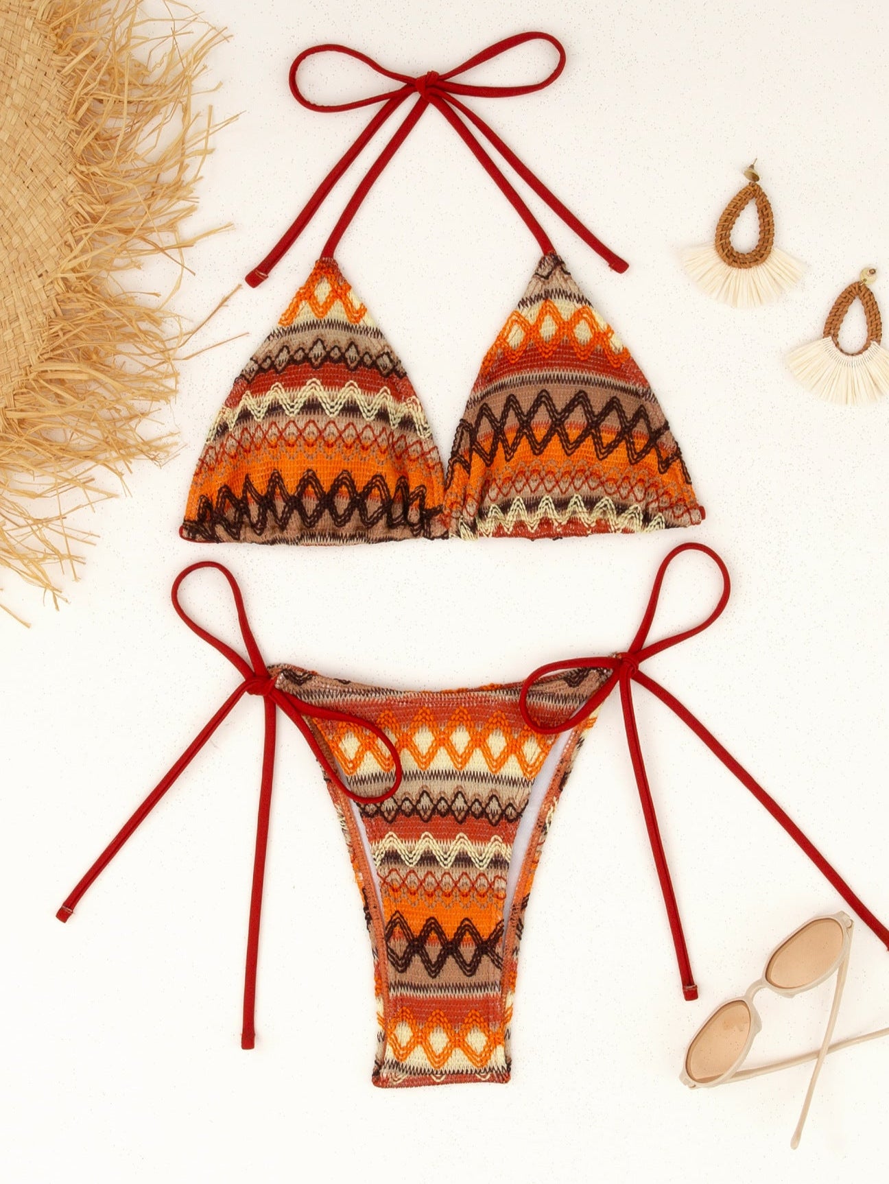 Orange and brown patterned bikini set with red straps on a white background