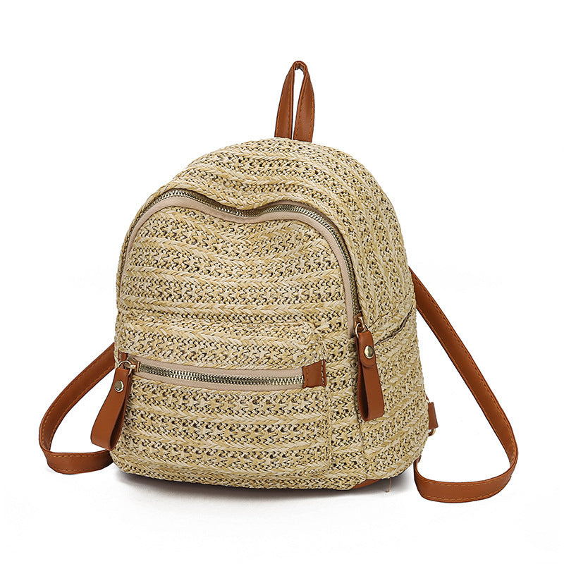 Woven straw backpack with brown straps on a white background