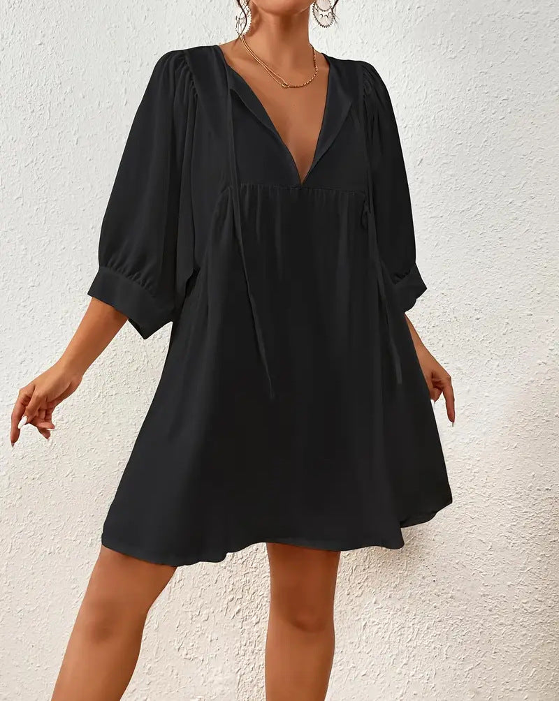 Black dress worn by a person against a white wall