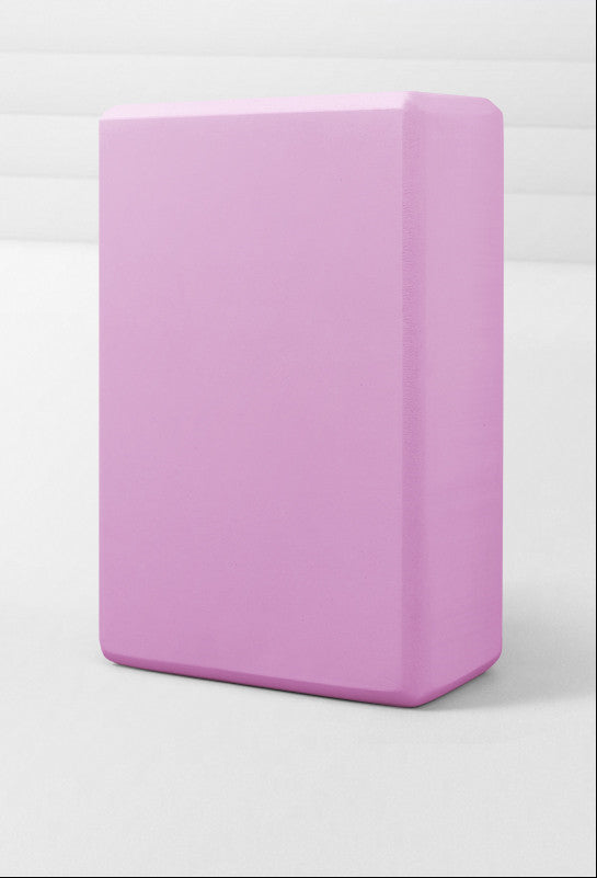 Pink yoga block on a white background