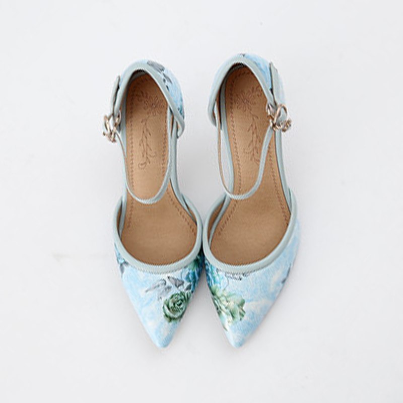Pair of light blue floral high heels on a white background