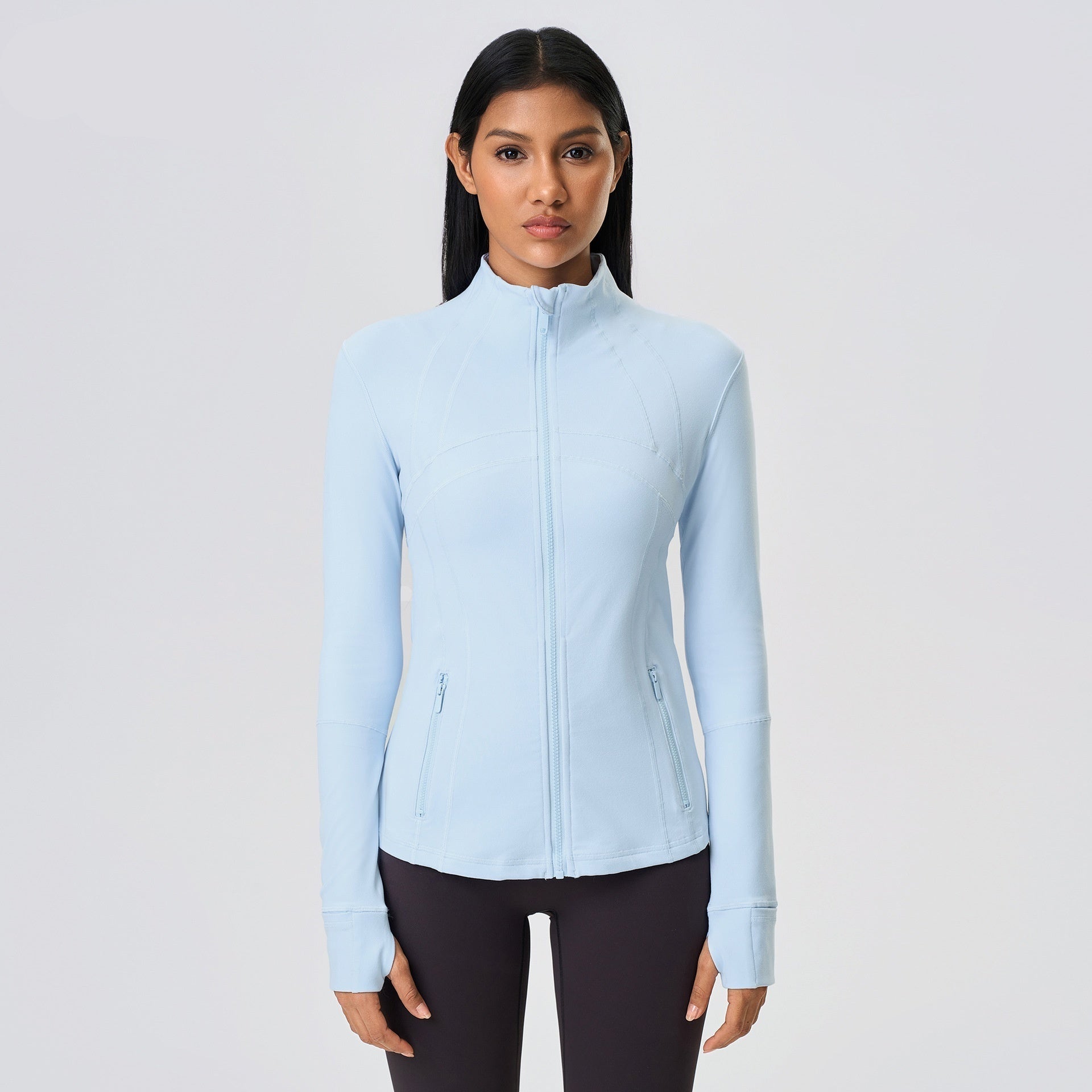 Woman wearing a light blue jacket on a gray background