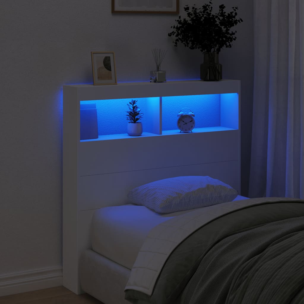 Bedroom with a headboard illuminated by blue LED lights, featuring decorative items.