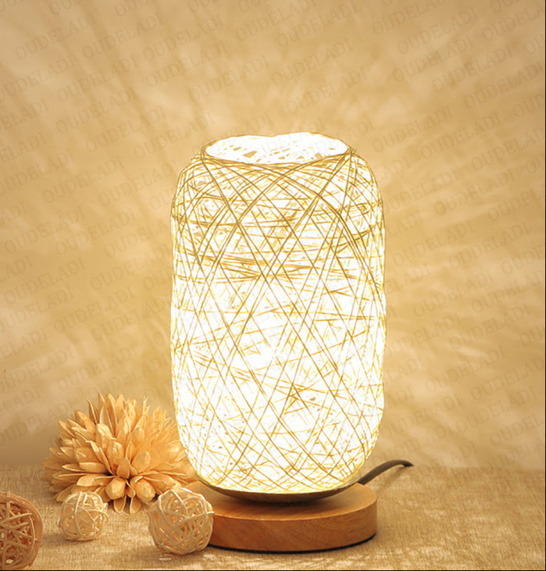 Woven lamp with warm glow on a textured surface