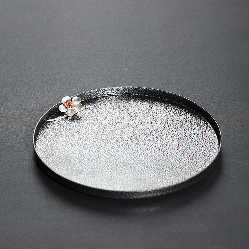 Decorative branch with birds on a black base against a dark background