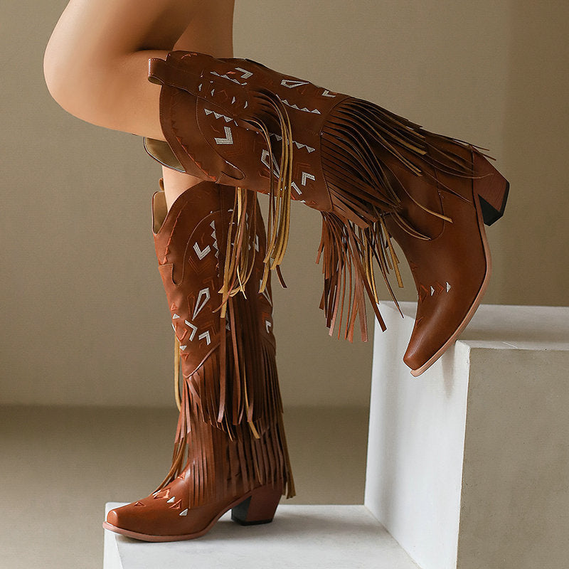 Brown fringed boots on a neutral background