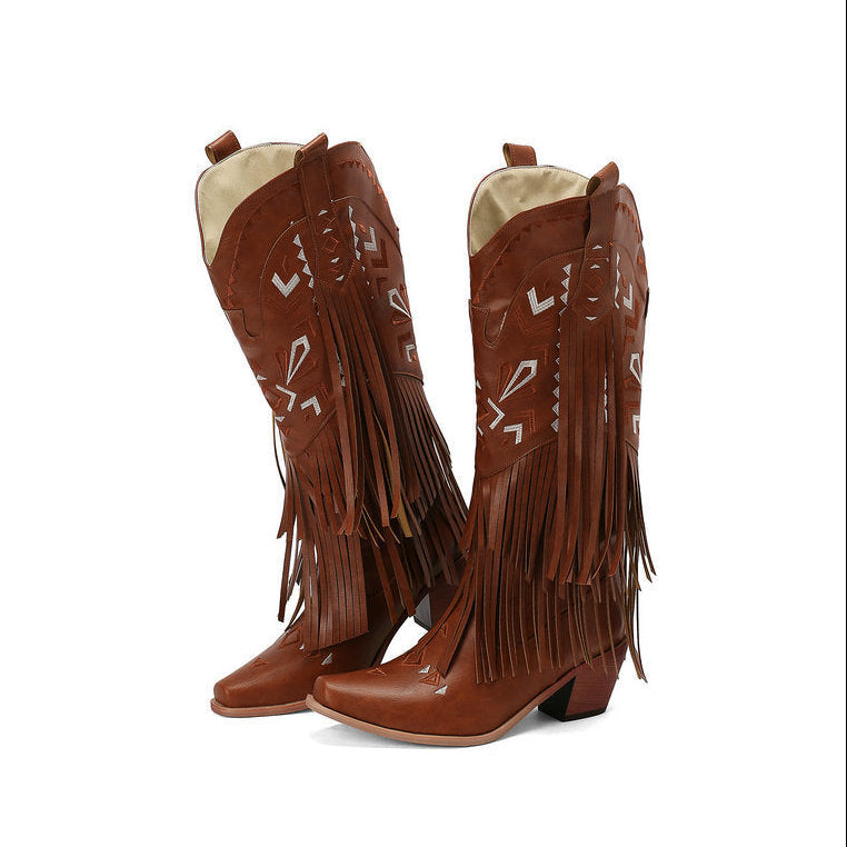 Pair of brown cowboy boots with fringes on a white background