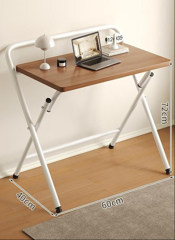 Foldable desk with light walnut top and white frame, placed on a wooden floor.