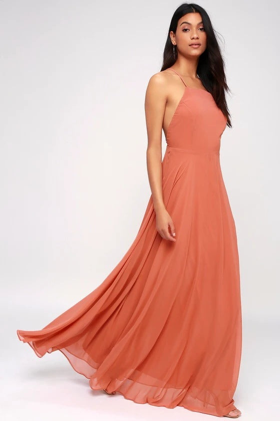 Woman wearing a long coral dress on a white background