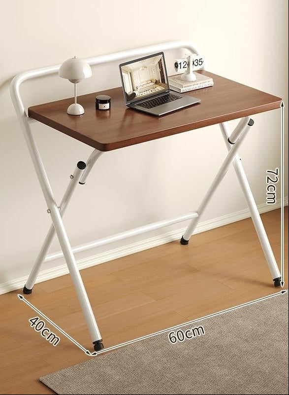 Folding desk with wooden surface and white metal frame, placed on a wooden floor.
