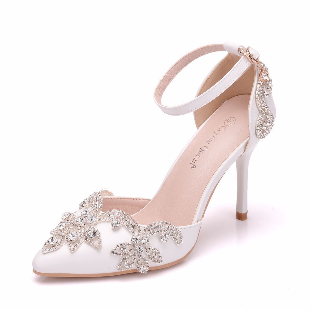 White high-heeled shoe with decorative embellishments on a white background