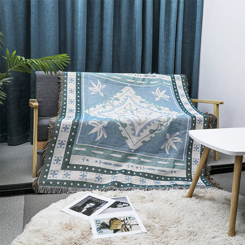 Decorative throw blanket with geometric pattern on a chair in a living room setting.