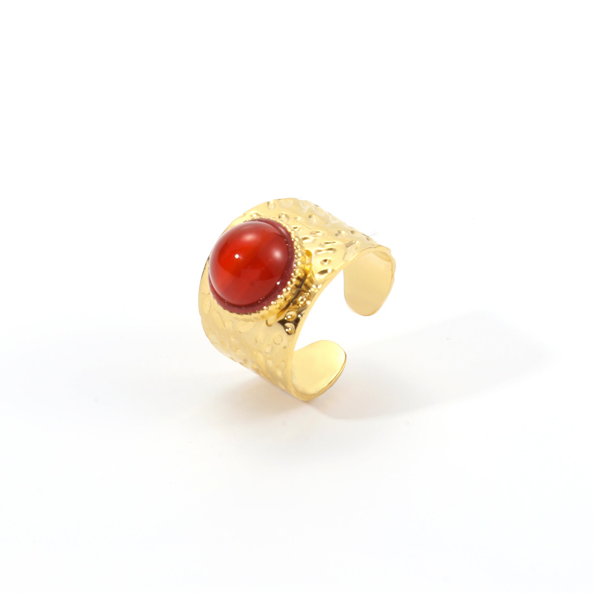 Gold ring with a red stone on a white background