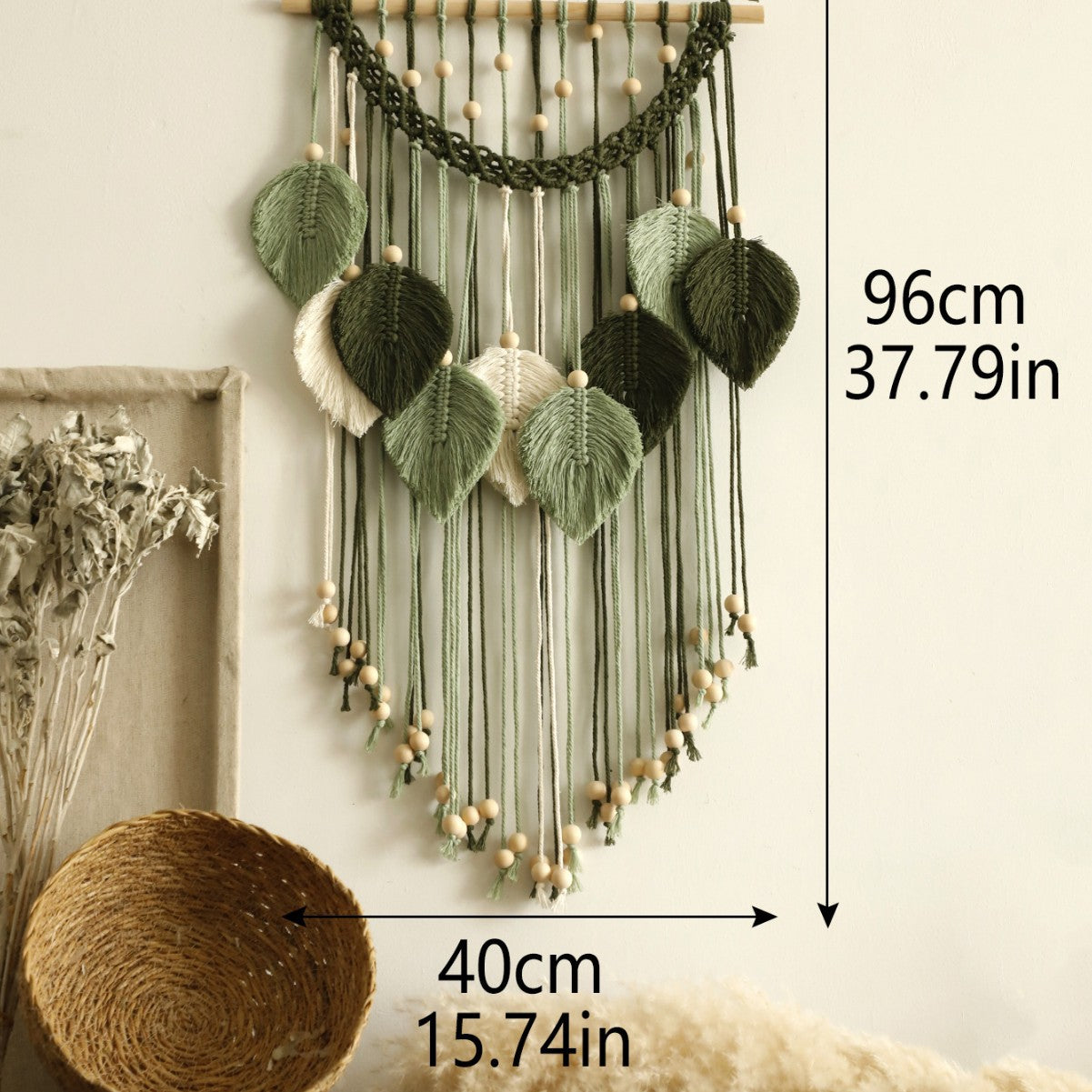 Decorative wall hanging with leaves and yarn, showing measurements on a neutral background.