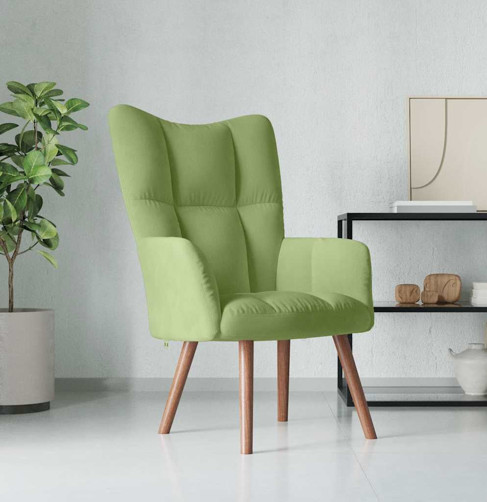 Green armchair in a modern living room with a plant and decorative items.