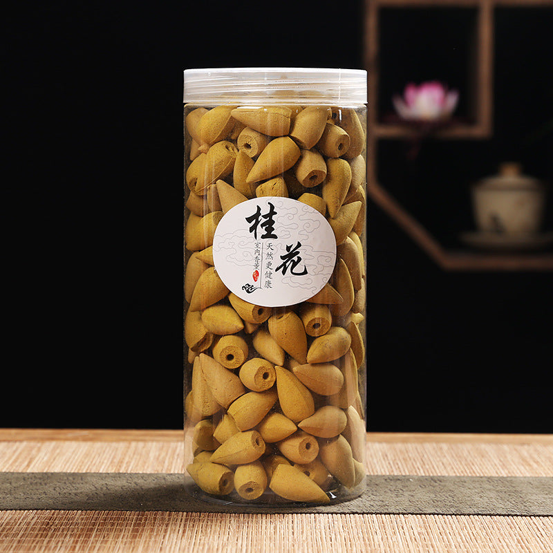 yellow incense cones in a cylindrical container with a label on a wooden surface.