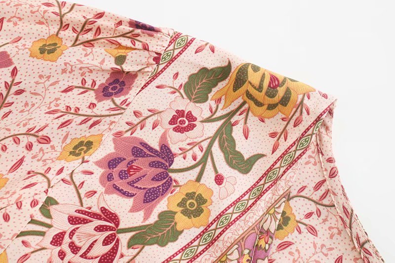 Close-up of floral fabric with pink, yellow, and green colors on a white background