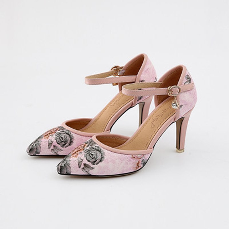 Pink high-heeled shoes with floral design on a white background