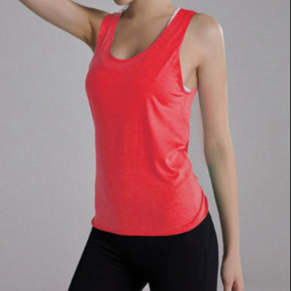 Woman wearing a red tank top and black pants on a gray background