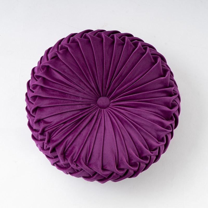 Purple round pillow with pleated texture on a white background