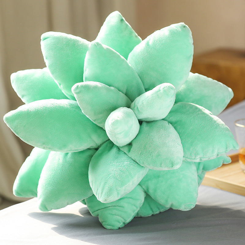 Green succulent-shaped pillow on a surface with a blurred background