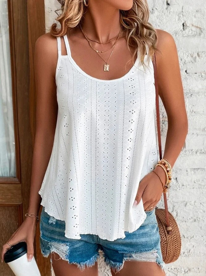 Woman wearing a white lace tank top and denim shorts, holding a coffee cup.