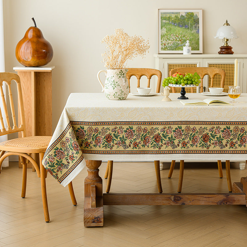 Dining room with a wooden table and chairs, floral-patterned tablecloth, and decorative items.