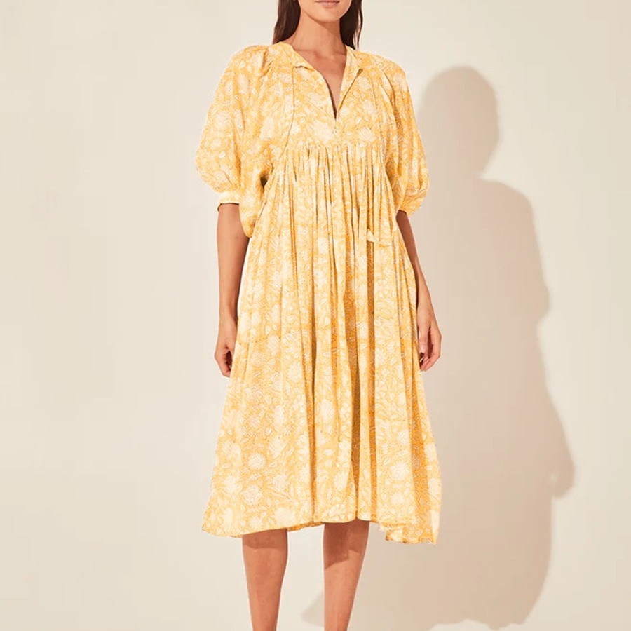 Woman wearing a yellow dress with a white background